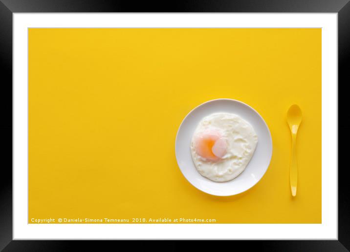 Fried egg in a plate on a yellow background Framed Mounted Print by Daniela Simona Temneanu