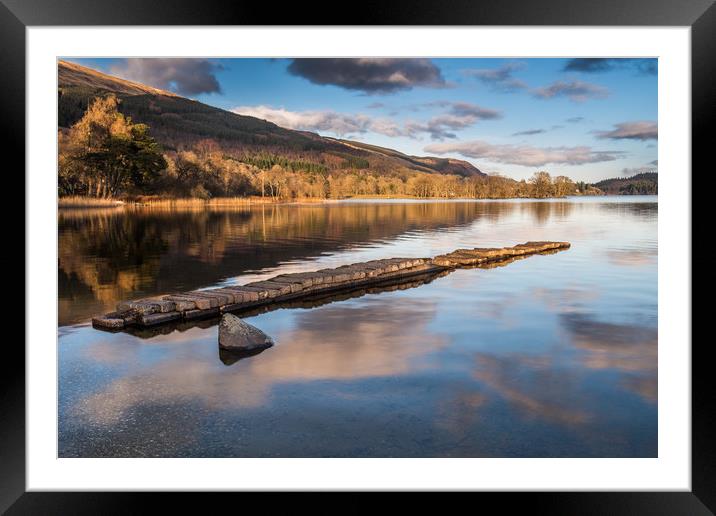 The old stone jetty on the shore of a very still L Framed Mounted Print by George Robertson