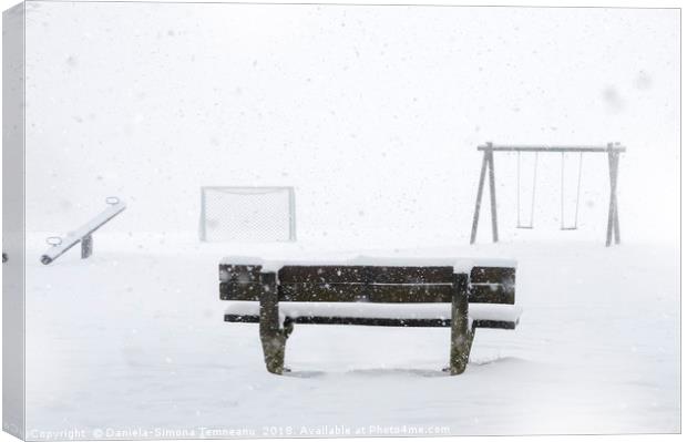 Playground and bench covered by snow Canvas Print by Daniela Simona Temneanu