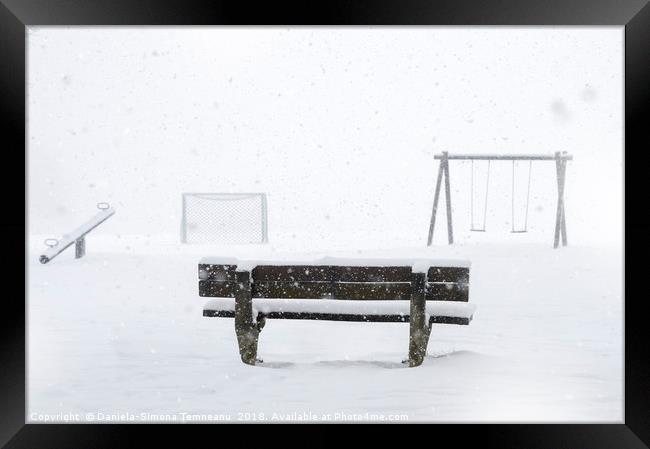 Playground and bench covered by snow Framed Print by Daniela Simona Temneanu