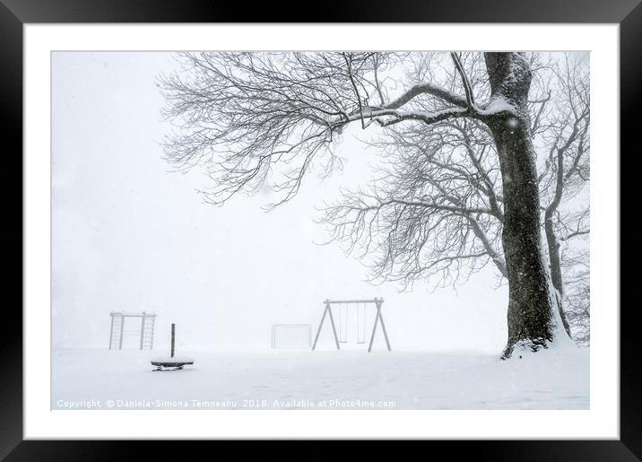 Snowstorm over an empty playground Framed Mounted Print by Daniela Simona Temneanu