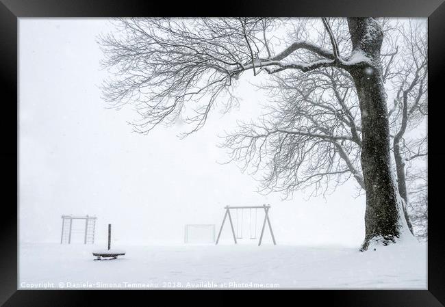 Snowstorm over an empty playground Framed Print by Daniela Simona Temneanu