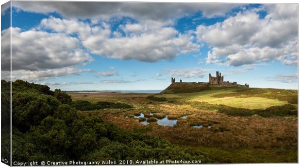 Dunstanburgh Castle on the Northumberland Coast Canvas Print by Creative Photography Wales