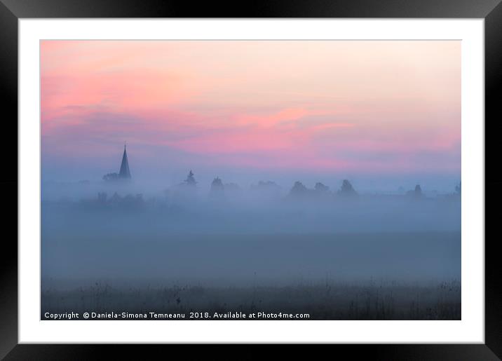 Church tower and village in fog at dawn Framed Mounted Print by Daniela Simona Temneanu