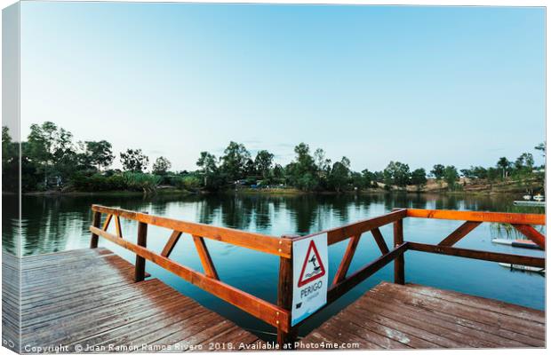 Wooden jetty with danger sign jumping into the wat Canvas Print by Juan Ramón Ramos Rivero