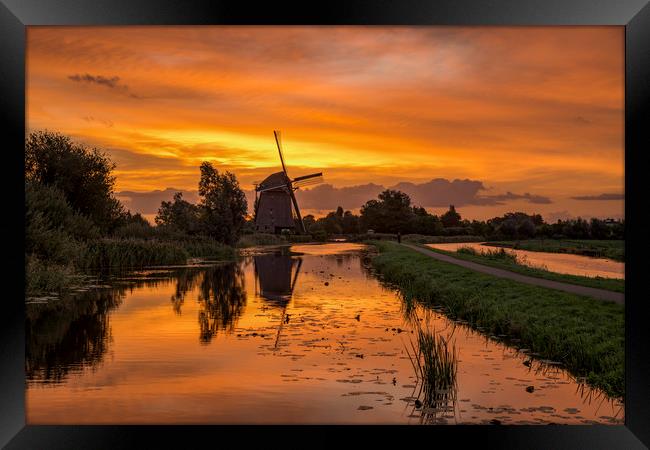 Windmill at the warm and red color sunrise in Haze Framed Print by Ankor Light