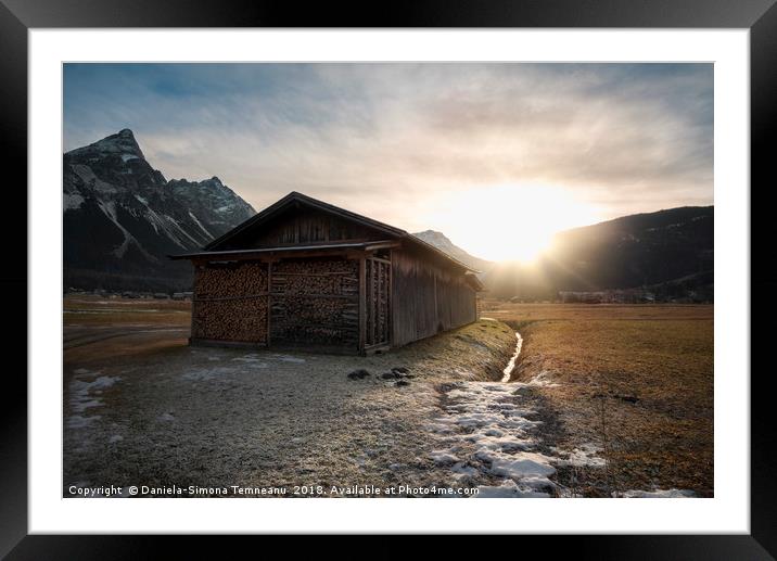 Barn with firewood at sunset in the Alps Framed Mounted Print by Daniela Simona Temneanu