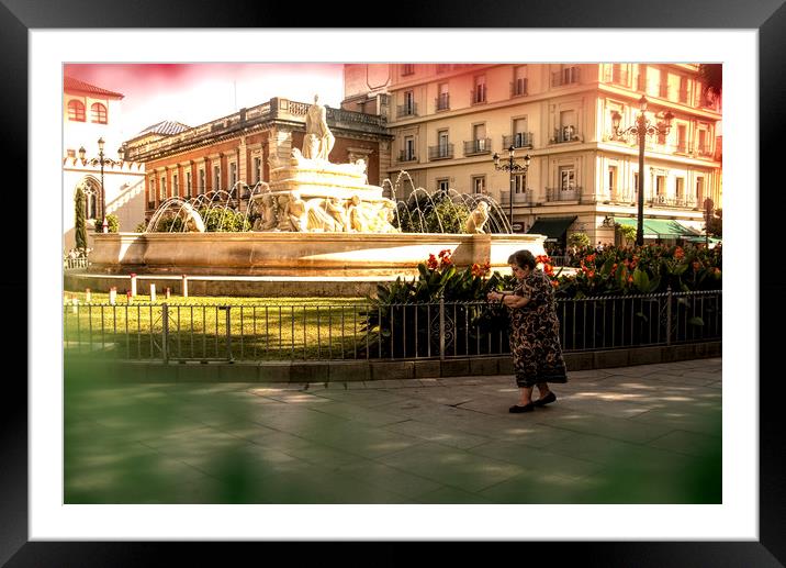 An old lady is walking in front of a fountain Framed Mounted Print by Jose Manuel Espigares Garc