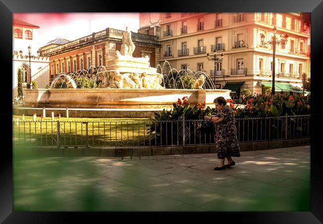 An old lady is walking in front of a fountain Framed Print by Jose Manuel Espigares Garc