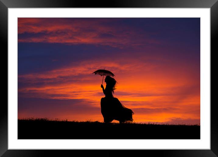 Silhouette of young woman running at sunset Framed Mounted Print by Maggie McCall