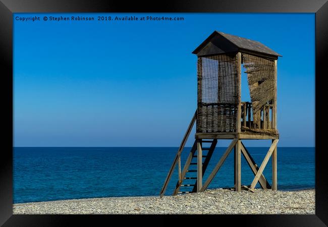 A rustic wooden lifeguard's hut on a shingle beach Framed Print by Stephen Robinson