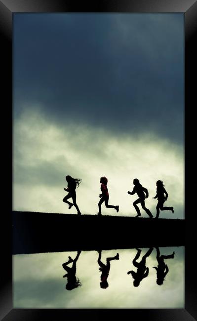 Reflection of Silhouetted girls Running. Framed Print by Maggie McCall