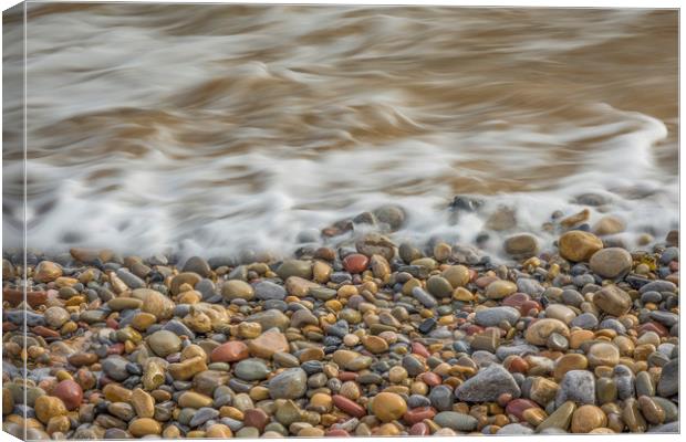 Pebbles being washed over by the sea. Canvas Print by Bryn Morgan