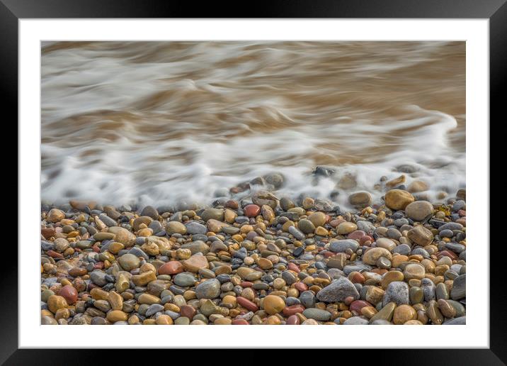 Pebbles being washed over by the sea. Framed Mounted Print by Bryn Morgan