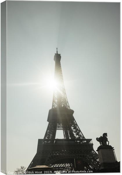 Sun shining through the Eiffel Tower Canvas Print by Nick Hirst