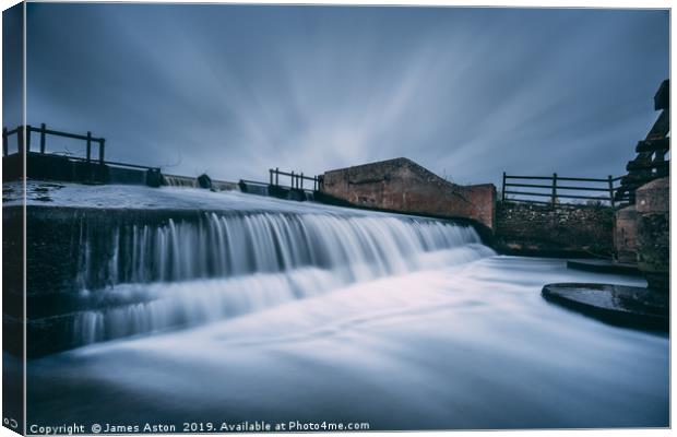 Slow Moving Water over the Weir Canvas Print by James Aston
