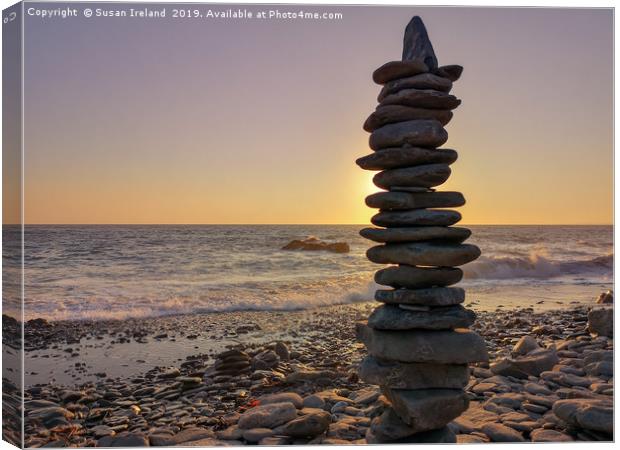 Stacked stones before a sunset  Canvas Print by Susan Ireland