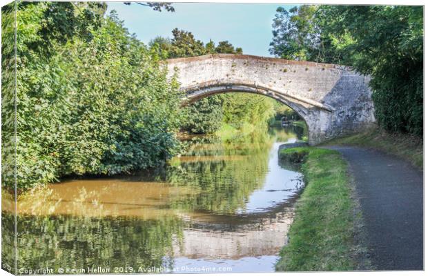 Bridge with reflection over the Shropshire Union c Canvas Print by Kevin Hellon