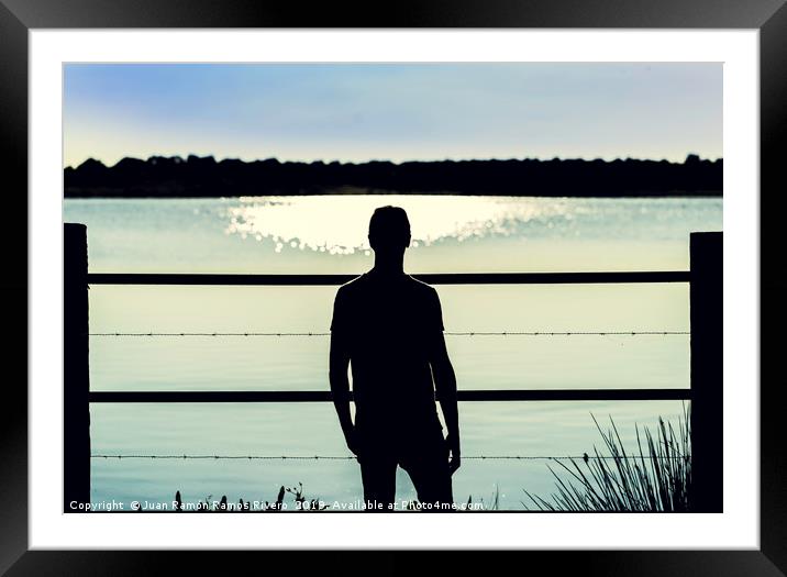 Silhouette guy standing  in the barbed wire fence Framed Mounted Print by Juan Ramón Ramos Rivero