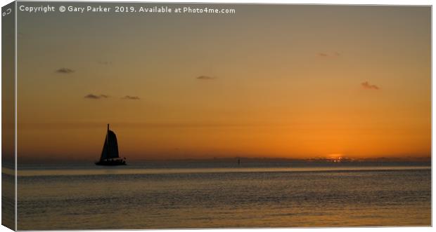 A sailboat , sailing past a tropical sunset	  Canvas Print by Gary Parker