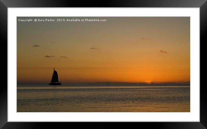 A sailboat , sailing past a tropical sunset	  Framed Mounted Print by Gary Parker