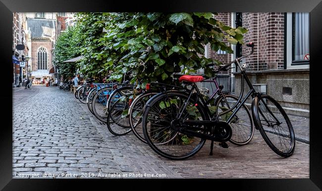Multiple bicycles parks on a Dutch street Framed Print by Gary Parker