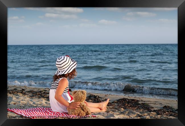 little girl with teddy bear sitting on beach Framed Print by goce risteski