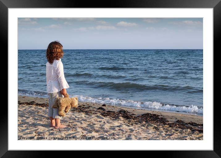 little girl with teddy bear standing on beach and  Framed Mounted Print by goce risteski