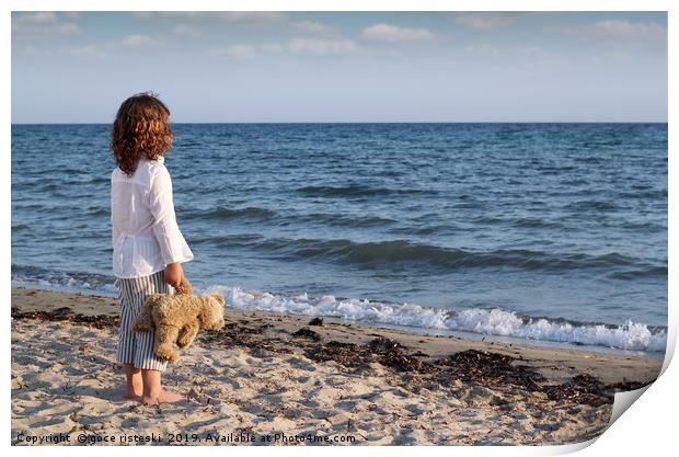 little girl with teddy bear standing on beach and  Print by goce risteski