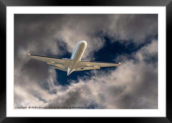 Airplane flying through a hole in storm clouds Framed Mounted Print by Andis Atvars
