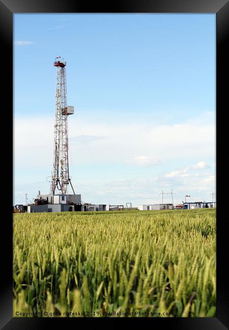 oil drilling rig on green wheat field Framed Print by goce risteski