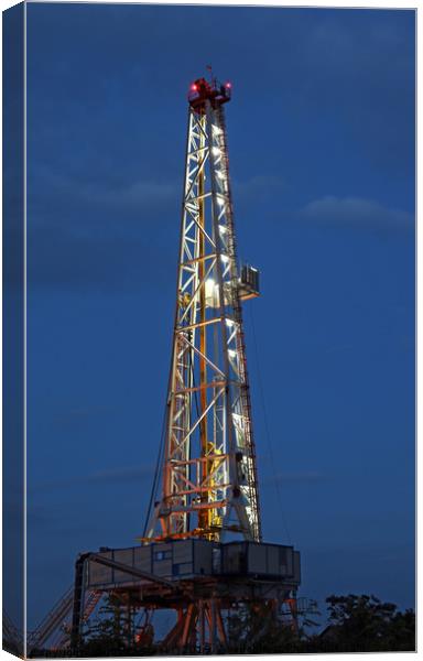illuminated oil drilling rig on oilfield Canvas Print by goce risteski