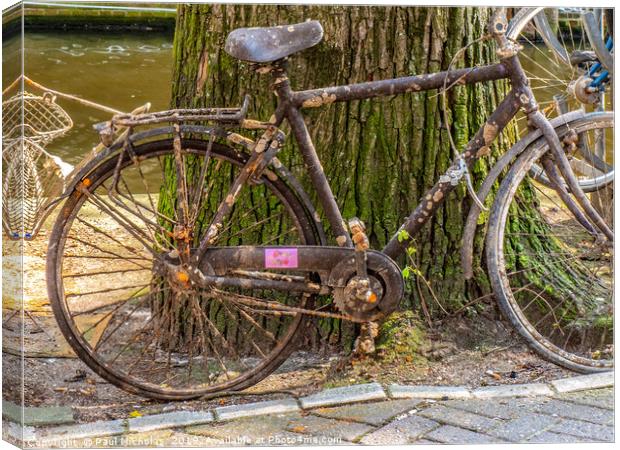 Abandoned bike on an Amsterdam canal-side Canvas Print by Paul Nicholas
