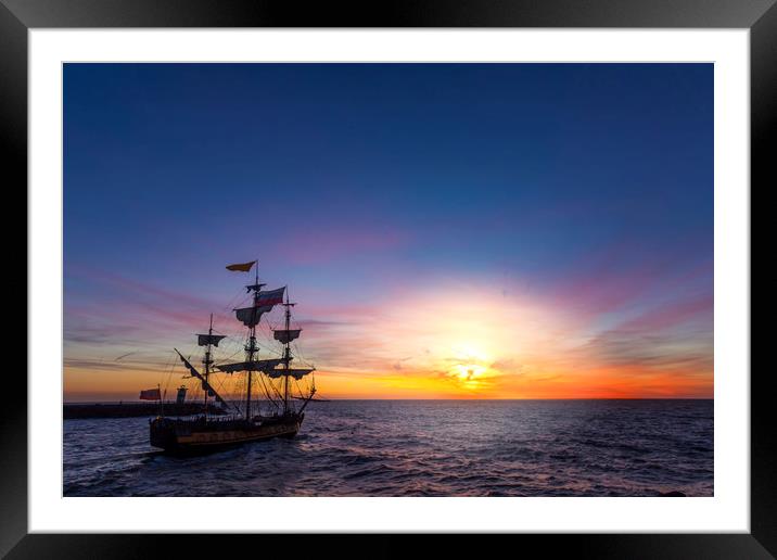 Silhouette of a pirate ship leaving the harbor Framed Mounted Print by Ankor Light