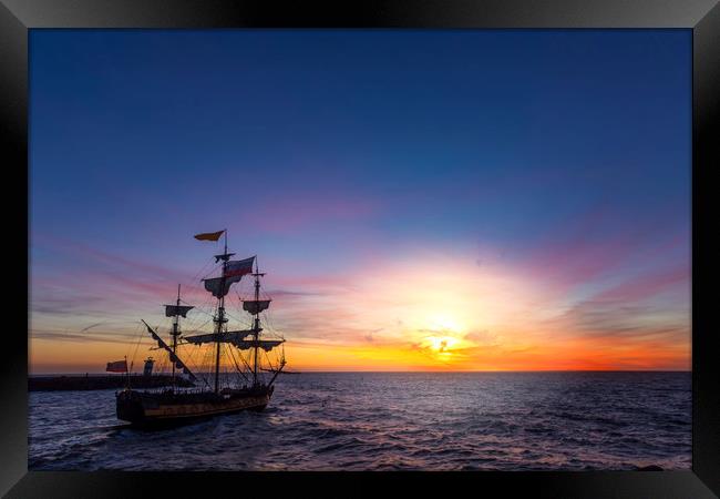 Silhouette of a pirate ship leaving the harbor Framed Print by Ankor Light