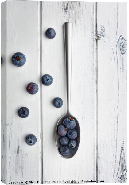 blueberries and a silver spoon on distressed white Canvas Print by Phill Thornton