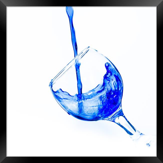 Pouring water into a wine glass Framed Print by David Strange