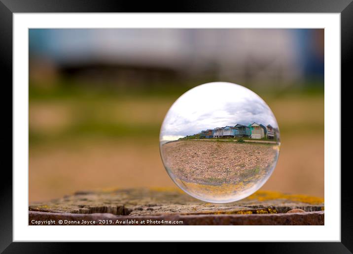 Beach huts through a Lensball Framed Mounted Print by Donna Joyce