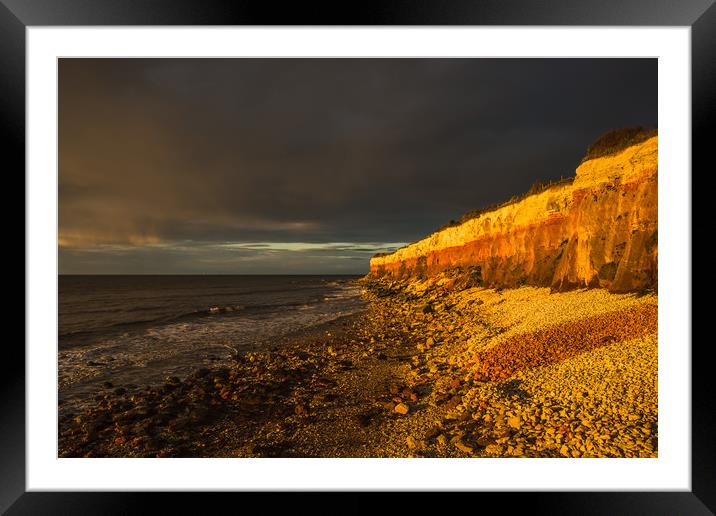 Hunstanton Cliffs at sunset with dark stormy sky Framed Mounted Print by Andrew Michael