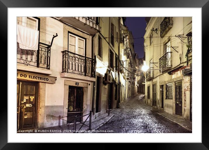 A narrow stone street empty in Lisbon. Framed Mounted Print by RUBEN RAMOS