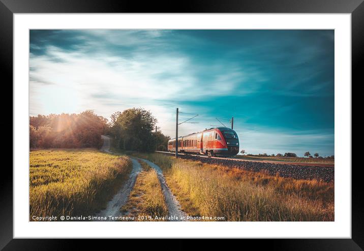 High-speed train moving through nature at sunset Framed Mounted Print by Daniela Simona Temneanu