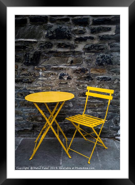 Yellow chair and table by stone wall  Framed Mounted Print by Mehul Patel