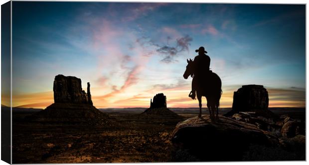 Silhouette of a cowboy at sunset Canvas Print by Guido Parmiggiani