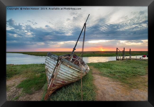 Sunrise over abandoned fishing boat on the shore a Framed Print by Helen Hotson