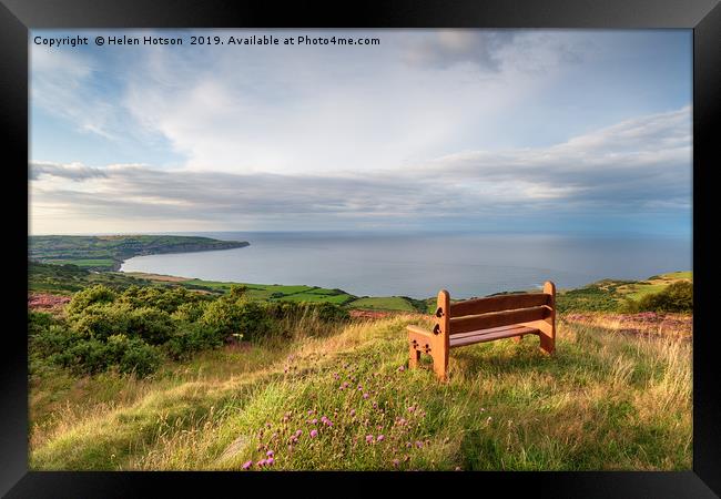 A wooden bench facing out to sea above Ravenscar o Framed Print by Helen Hotson