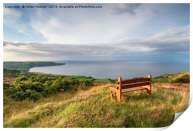 A wooden bench facing out to sea above Ravenscar o Print by Helen Hotson