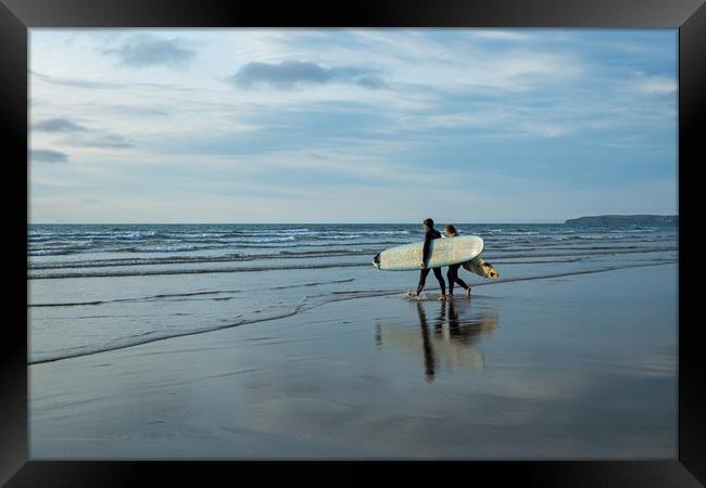 Surfer couple entering the sea at Westward Ho! Framed Print by Tony Twyman