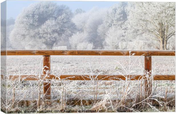 Rural winter snow scene and fence Canvas Print by Simon Bratt LRPS