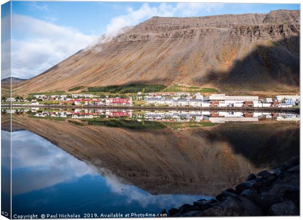 Isafjordur town in Iceland reflecting in the fjord Canvas Print by Paul Nicholas