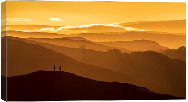 Two people stand on a mountain  Canvas Print by John Finney